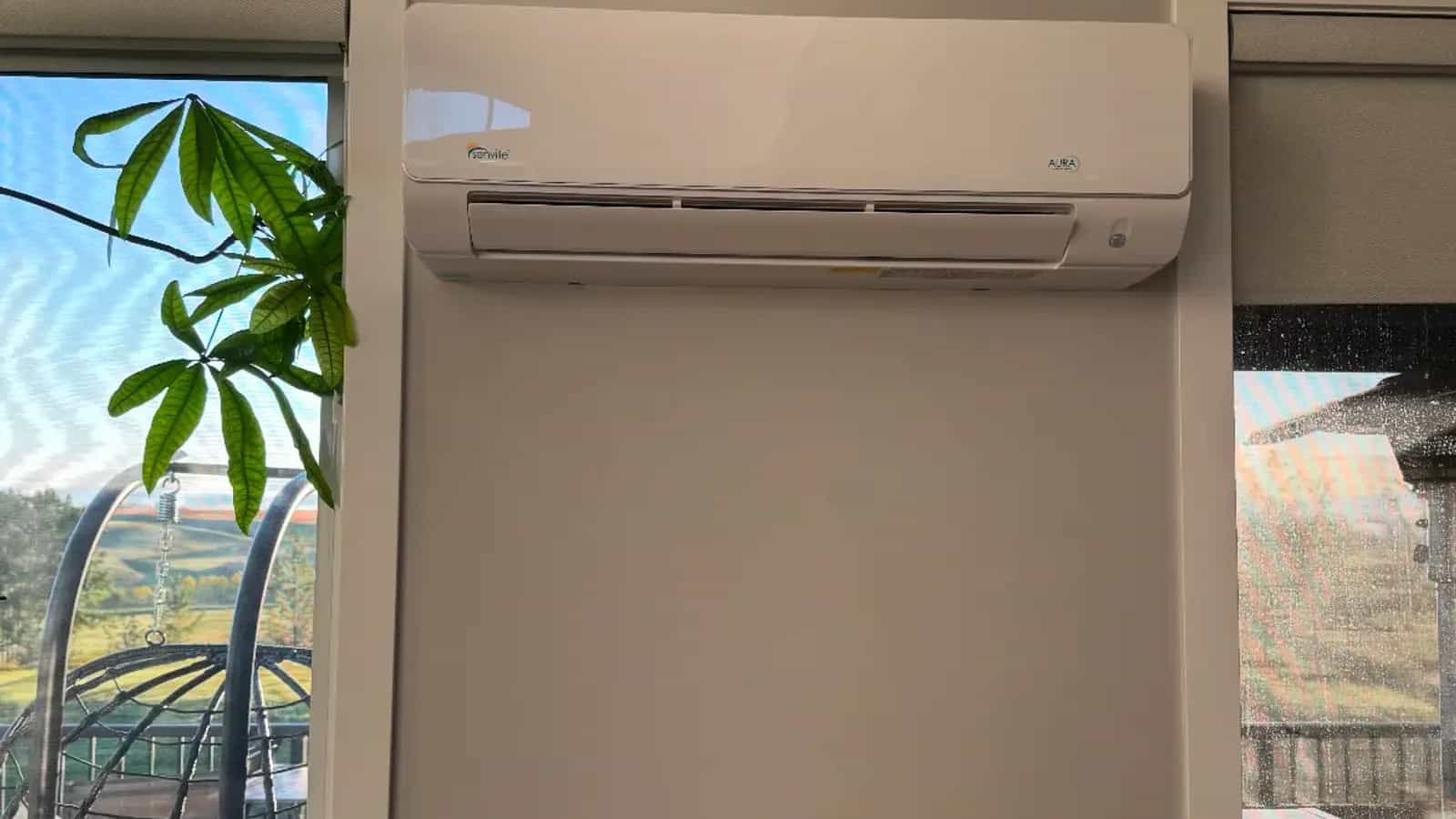 Ductless mini-split head mounted high on a bright living room wall