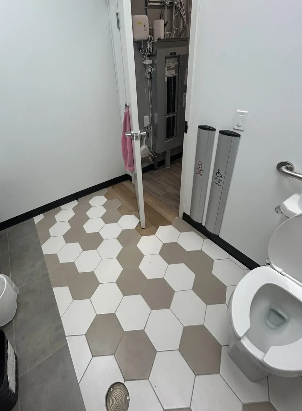 Finished accessible washroom with hex-tile feature floor, grab bars and push-to-open hardware
