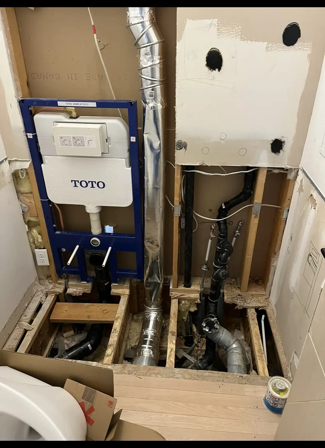In-wall toilet carrier and fresh rough-in exposed during a bathroom renovation