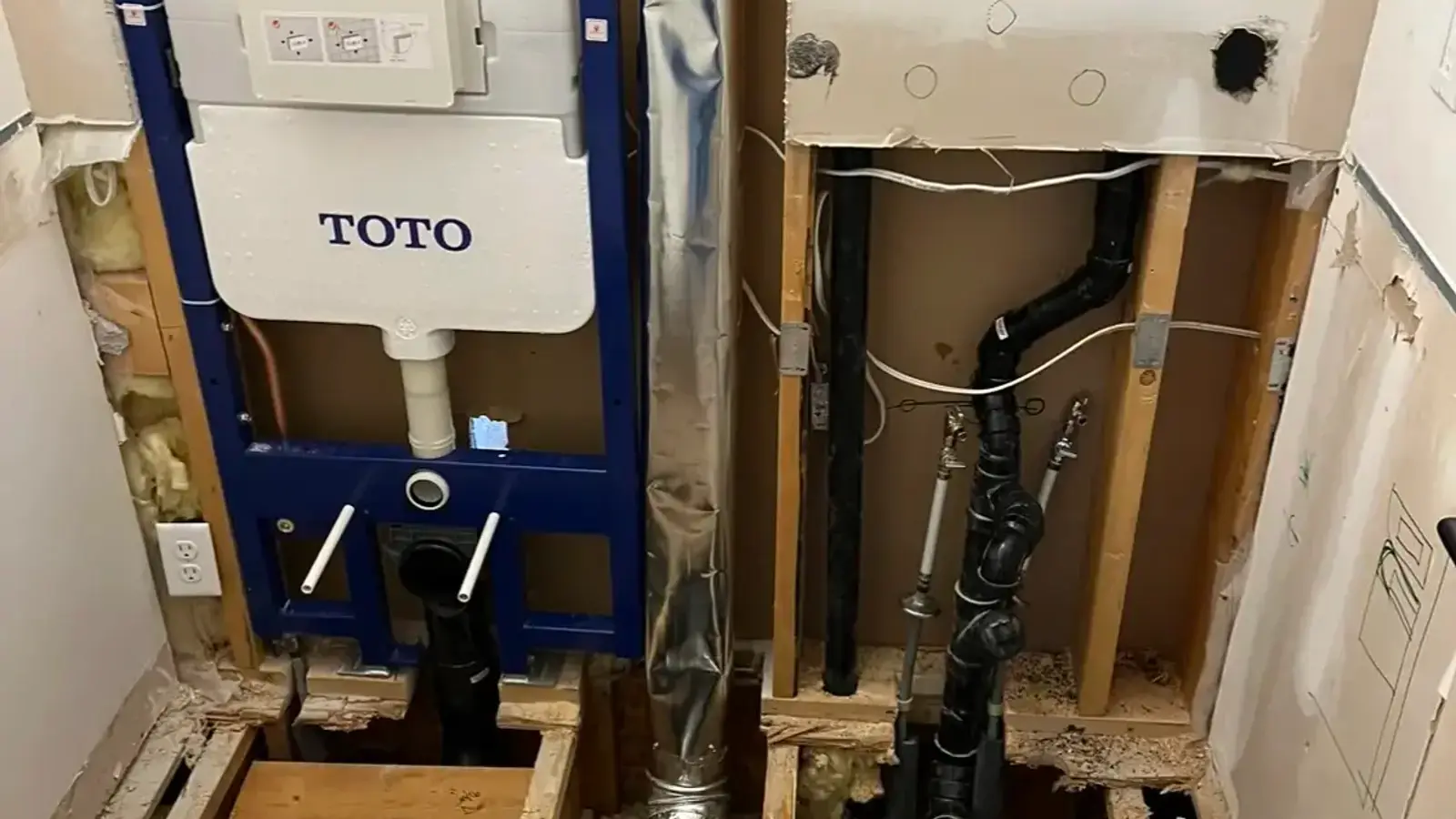 In-wall toilet carrier and fresh rough-in exposed during a bathroom renovation