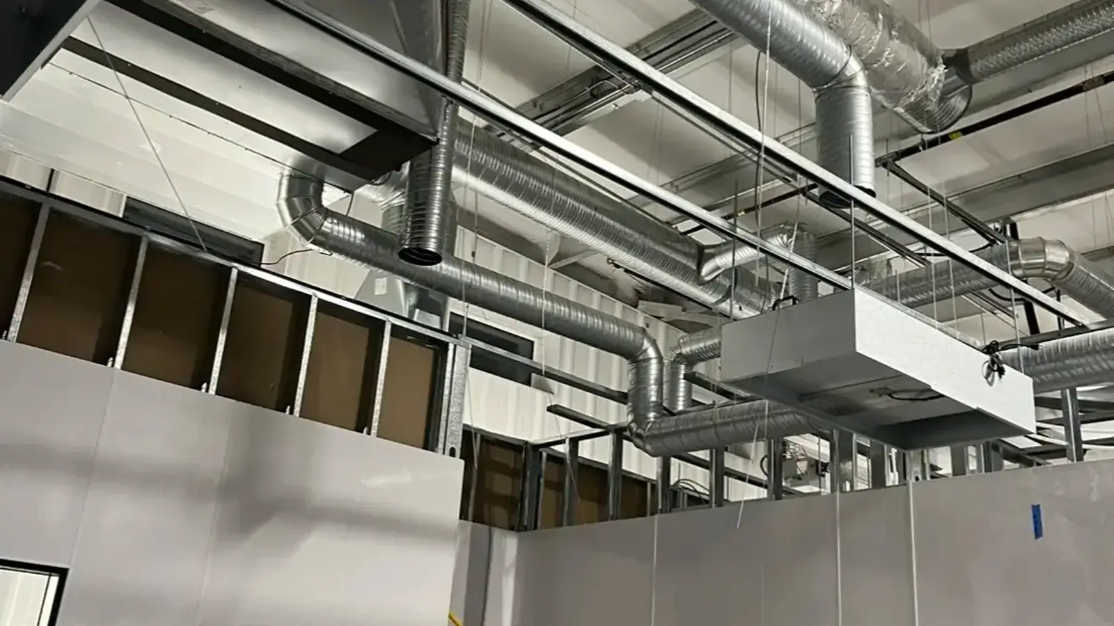 Insulated flex and spiral duct network above panel-built cleanrooms