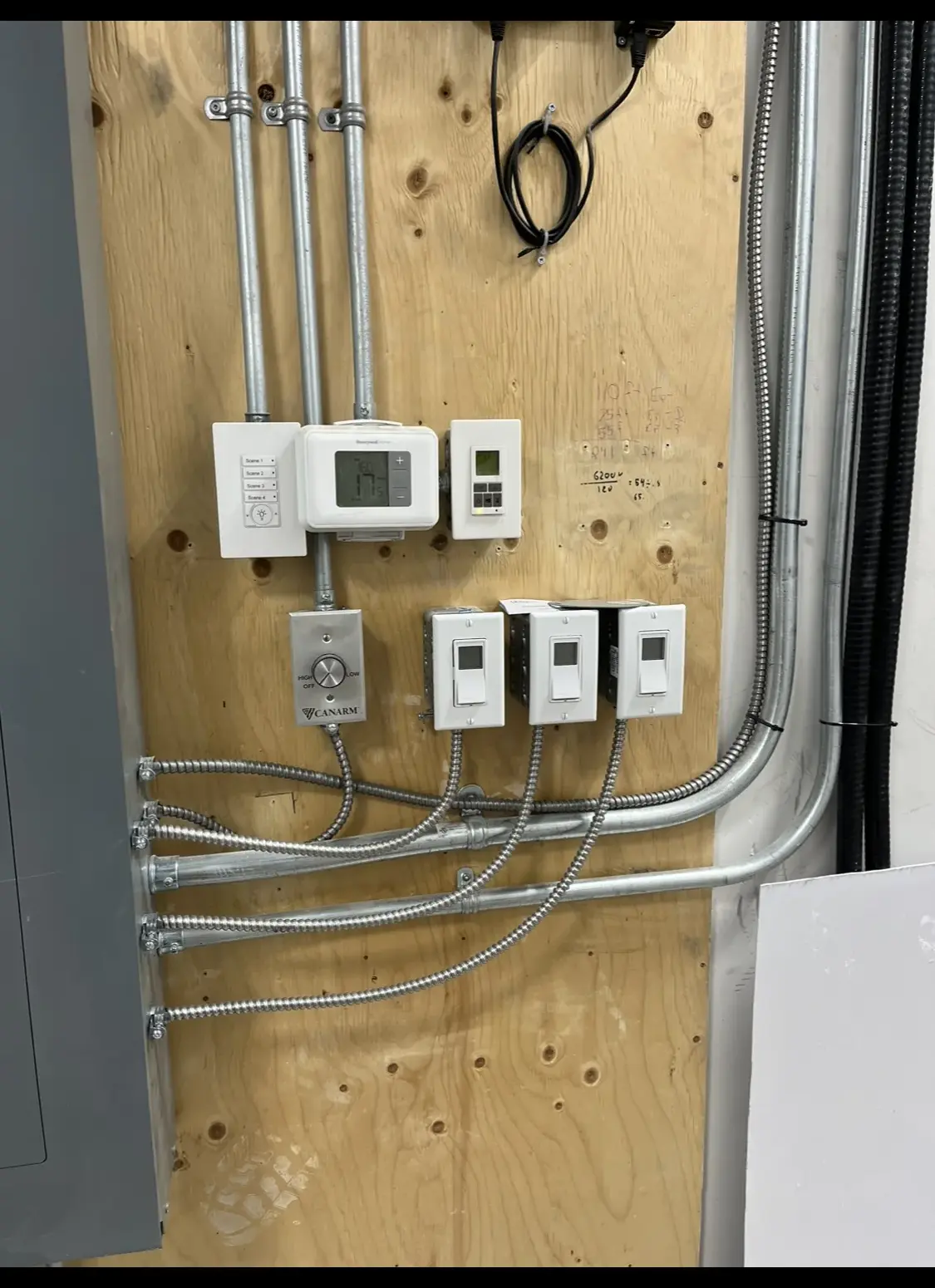Thermostat, timer and fan-speed controls wired to a plywood backboard