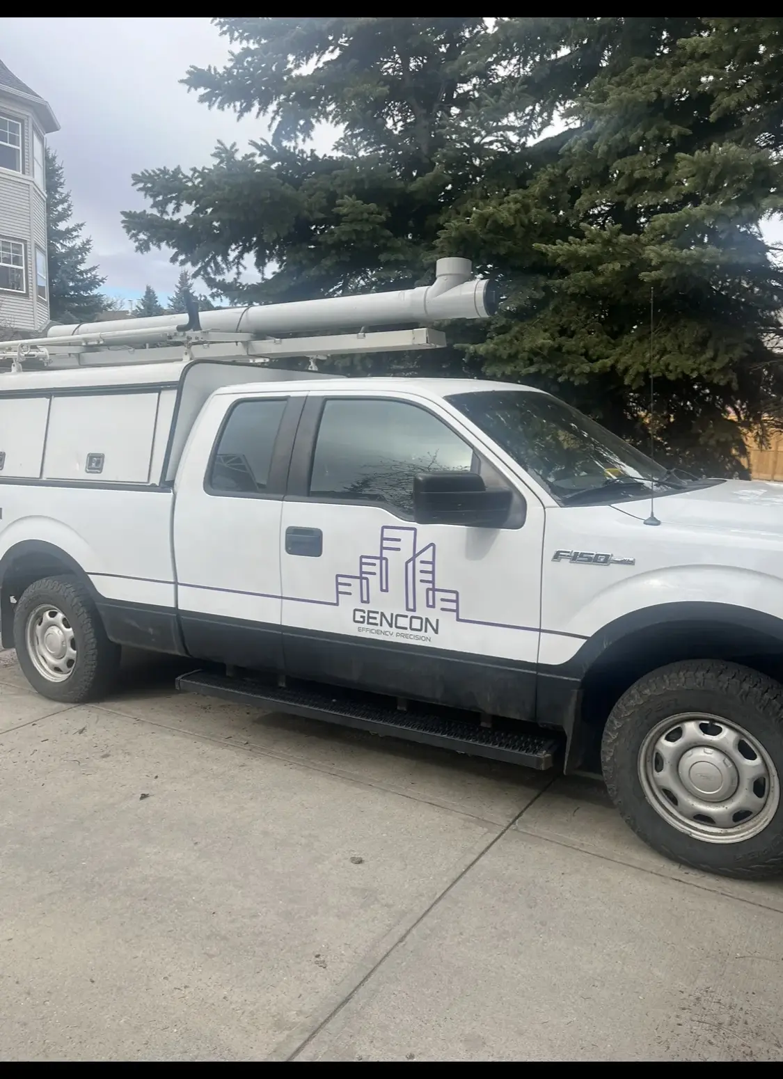 Gencon service truck with ladder rack parked outside a residential jobsite