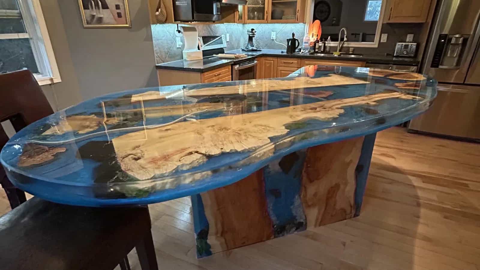 Live-edge island with a blue epoxy river top anchoring a family kitchen