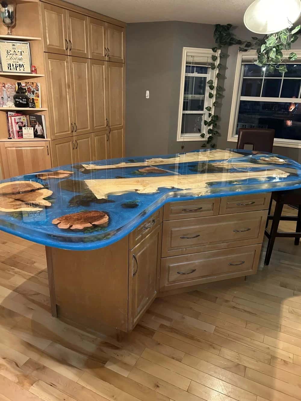 Custom epoxy river island with maple cabinetry in a finished kitchen